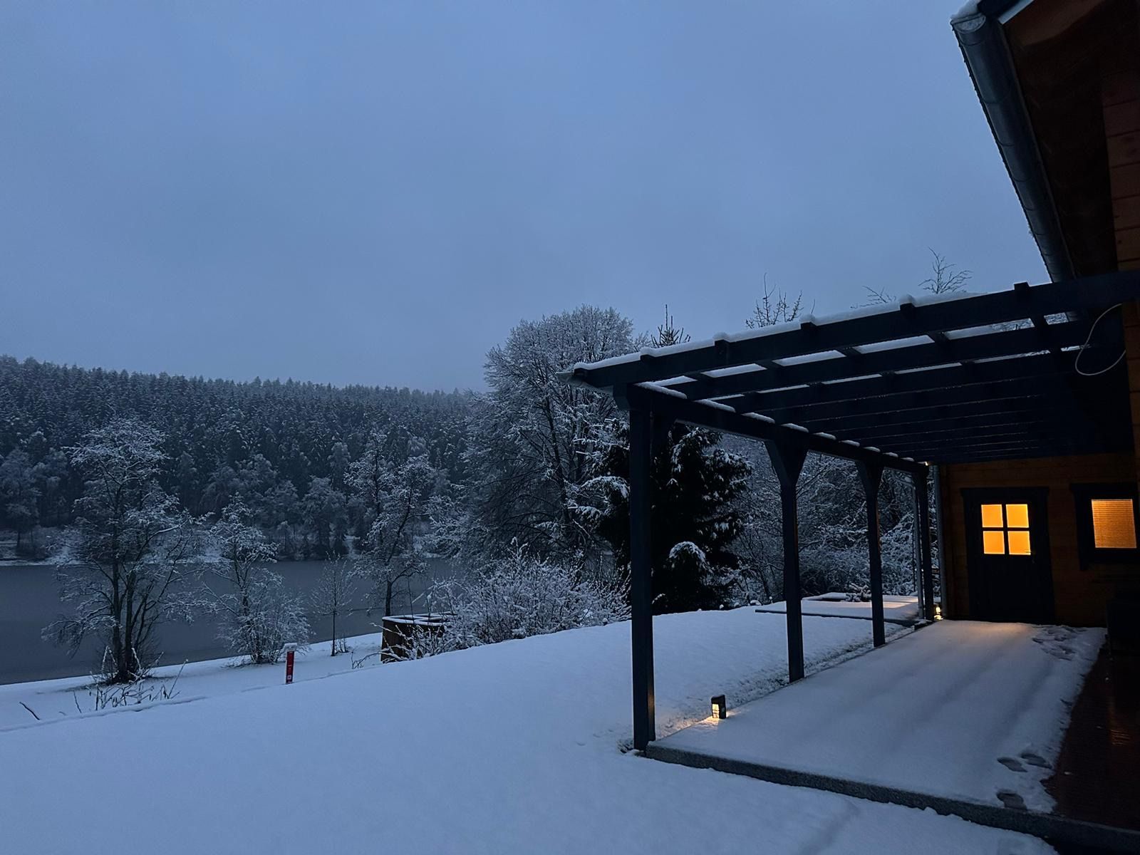 Das beleuchtete Sonnenhäuschen an einem Winterabend im Schnee